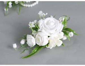 Close-up of elegant white artificial rose corsage with green leaves and small buds