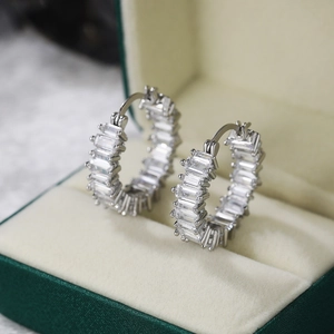 Macro view of silver tone hoop earrings with baguette-cut pavé set cubic zirconia