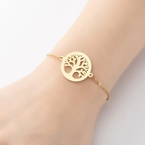 Close-up of a gold Tree of Life charm bracelet worn on a female wrist for a minimalist look