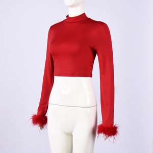 Detail of red mock neck crop top featuring elegant feather cuffs and sleek stretch fabric