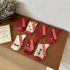 Festive red and cream mid-calf socks set with floral patterns and holiday gift tags