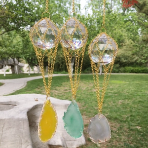 Close-up of crystal balls with gold mesh and colorful agate slices in a garden setting