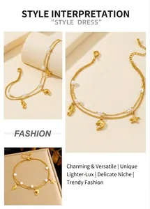 Detail of double-layer gold chain with sea charms and pearls on natural stone