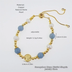 Detail of handmade 18k gold plated beaded bracelet with Virgin Mary medal and light blue stones