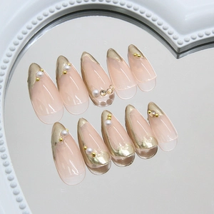 Goldene French Tip Almond Press-on Nägel mit Perlen auf herzförmiger Spiegelfläche