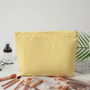 Seersucker cosmetic bag with yellow and white stripes and textured finish