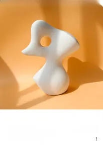 Detail van wit abstract keramisch beeldhouwwerk met minimalistische bochten en mat