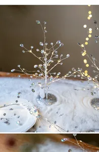 Macro shot of silver LED Christmas branch with crystal beads and warm white lights
