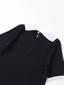 Detail view of the black knit top back with white collar and teardrop keyhole button closure