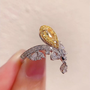Luxury crown ring with a pear-shaped yellow diamond and elegant silver diamond band