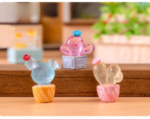 Three miniature glowing resin cacti figurines on a wooden stand for micro landscapes