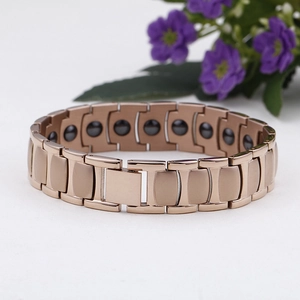 Detail of rose gold magnetic therapy bracelet with black stone inserts for health benefits
