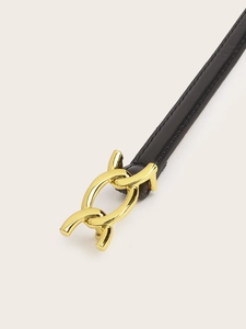 Detail of black leather belt featuring a polished gold chain link buckle on beige background