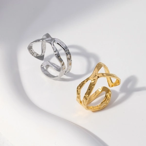 Macro detail of gold and silver crossover rings with hand-hammered texture