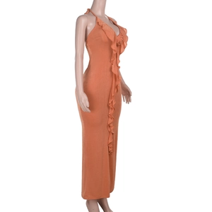 Detail of ruffle trim and 3D rose applique on a backless orange halter maxi dress