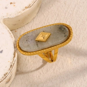 Detailed close-up of 18K gold plated oval ring with white marble stone and stud detail