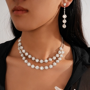 Two-piece silver necklace and floral drop earrings set with sparkling crystals for women
