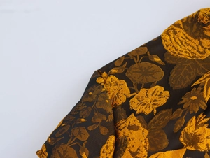 Close-up of vintage floral jacquard fabric with gold and brown brocade texture