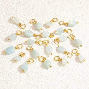 Macro detail of irregular light blue natural stone pendants with gold metal rings