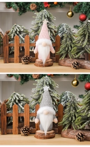 Detailed view of pink and grey knitted faceless gnomes with stars on wooden bases