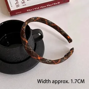 Detail shot showing a 1.7cm wide vintage brown plaid headband on a coffee cup