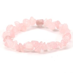 Macro shot of irregular pink crystal stones on an elastic bracelet against a white backdrop