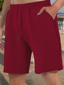 Close-up of wine red casual shorts featuring a drawstring waist and waffle knit texture