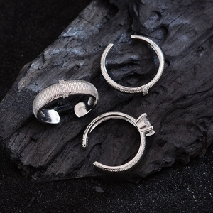 Three 925 silver rings with zircons and striped texture on a dark charcoal background