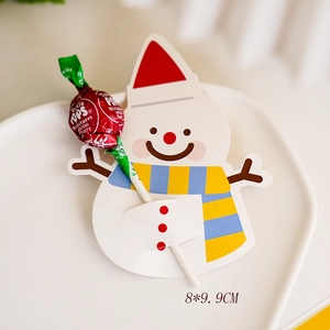 Detailed close-up of a snowman lollipop paper card decoration on a white plate