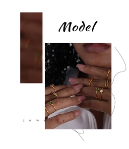 Detail of stacked gold rings featuring colorful oval gemstones on a model hand