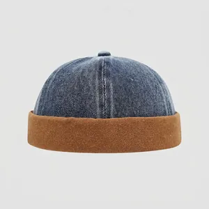 Detail der Kinder Docker-Mütze aus Denim im Colorblock-Design mit braunem Canvas-Umschlag