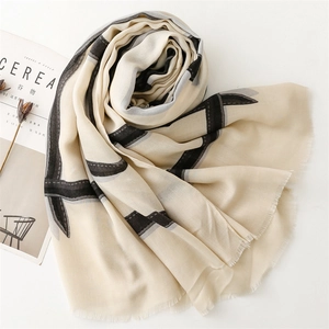 Detail of beige scarf with black stripes and soft fringe trim in cotton linen feel
