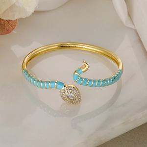 Detail of gold snake bangle featuring turquoise enamel and sparkling white cubic zirconia