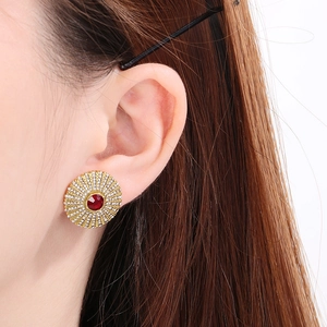Close-up of vintage titanium steel stud earring with red gemstone and pavé diamonds