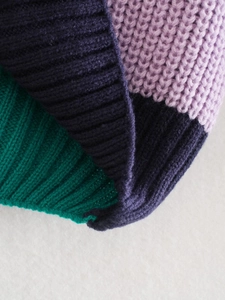 Dettaglio dei polsini in maglia a coste con vivace design color block viola, blu e verde