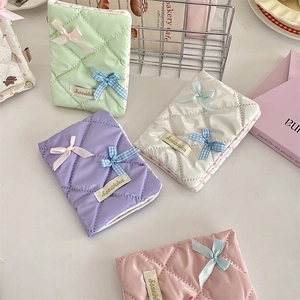 Detailed view of quilted fabric passport holders with elegant bows in pastel colors