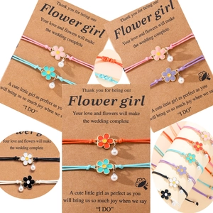 Detail of woven flower bracelets with pearls and colorful enamel charms on gift cards