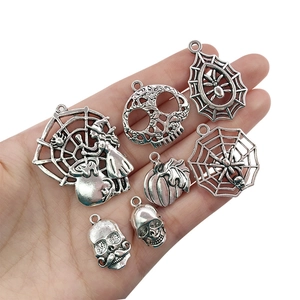 Detailed close-up of antique silver Halloween charms held in hand for jewelry DIY