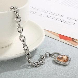 Detailed macro shot of an amber heart gemstone pendant on a chunky silver chain link