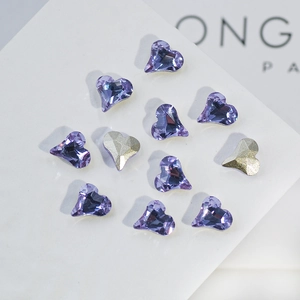 Macro shot of 11 heart-shaped K9 crystals in purple and champagne on a white base