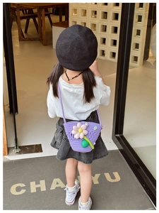 Close-up of girl wearing purple crochet crossbody bag with floral and pearl accents