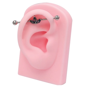 Piercing industriel en acier médical avec trois zircons marquise colorés sur modèle d'oreille