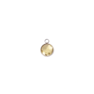 Detailed view of 7mm round birthstone charm with faceted yellow stone and silver frame