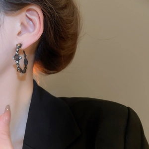 Detail of vintage tiger eye hoop earrings with silver needles and crystal star accents