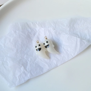 Detail of cute white 3D resin ghost charms with gold rings for DIY jewelry making