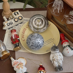 Detailed view of astronaut and Santa Claus resin ornaments in a vintage holiday setting