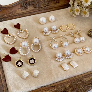 French vintage pearl and diamond fishtail earrings set on beige velvet jewelry tray