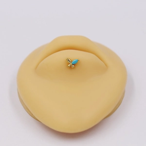 Detailed view of butterfly labret with sky blue gemstone on a silicone skin model