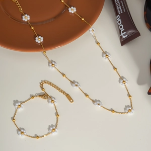 Détail de l'ensemble collier et bracelet à fleurs de perles tissées en acier doré