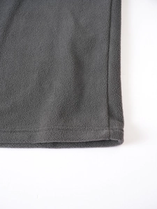 Detailed close-up of dark grey fleece texture and premium stitching on the garment hem